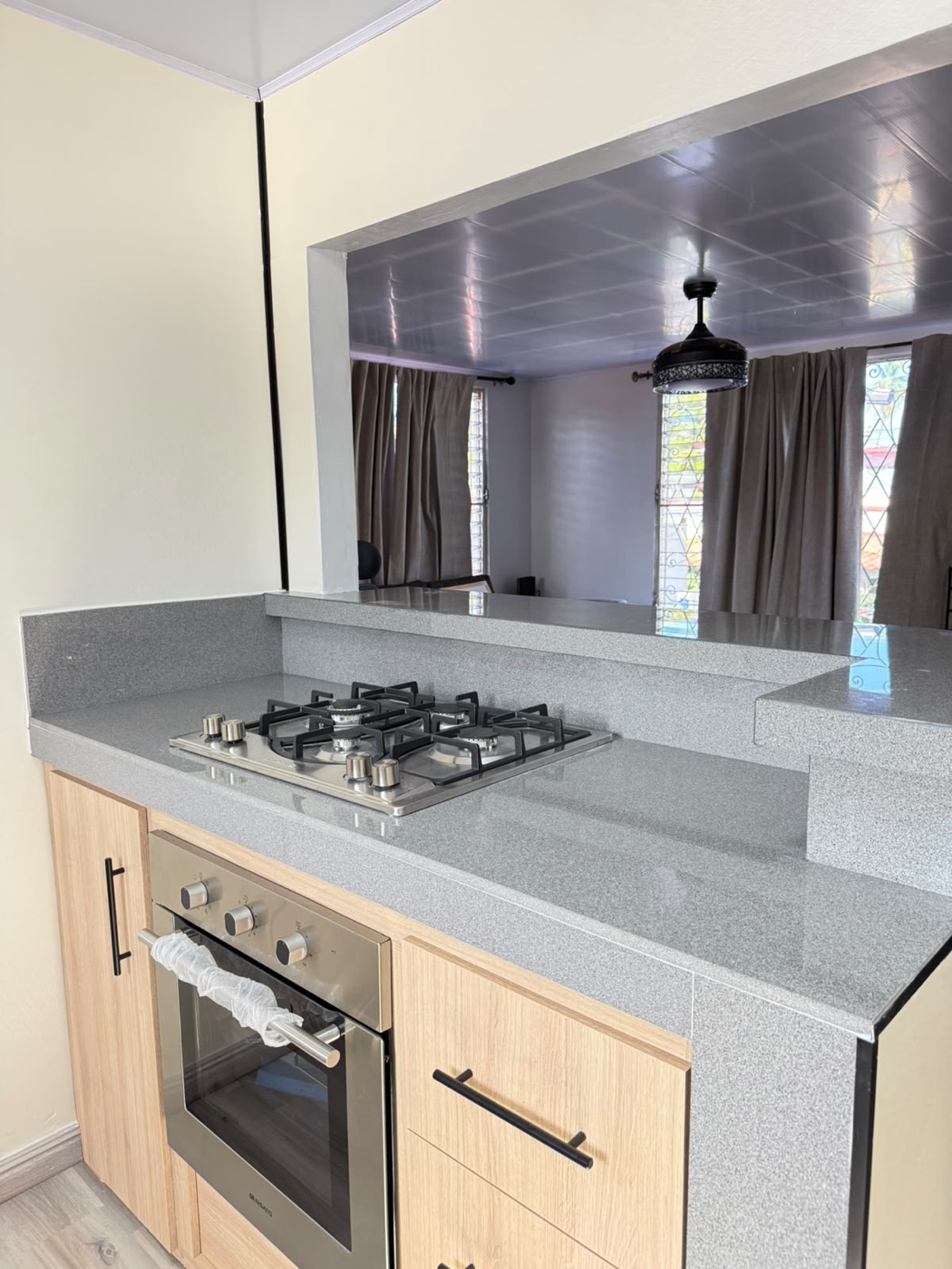 Cocina con sobre de granito y mobiliario en roble en apartamento renovado